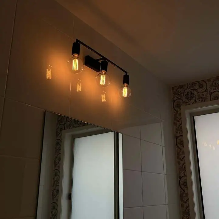Renovated bathroom with wall sconce lighting by BPE Solutions