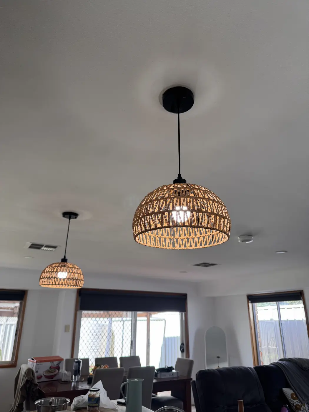 Rattan pendant lights installed over a dining area by BPE Solutions